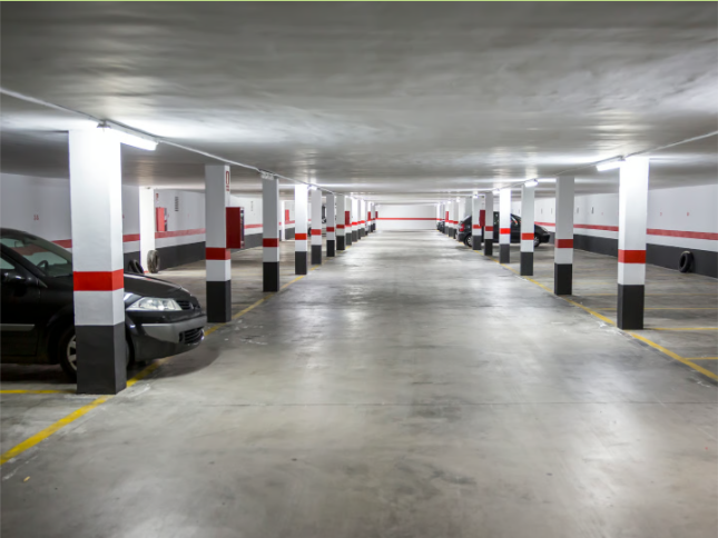 Tiefgarage mit markierten Stellplätzen und parkenden Autos